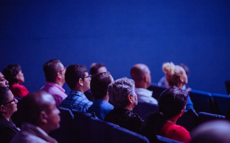 People sitting in audience, watching a presentation