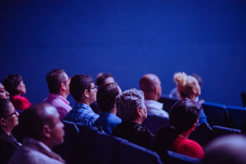 People sitting in audience, watching a presentation