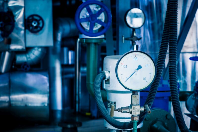 Pressure vessel in focus in front of blue machine (out of focus) in the background