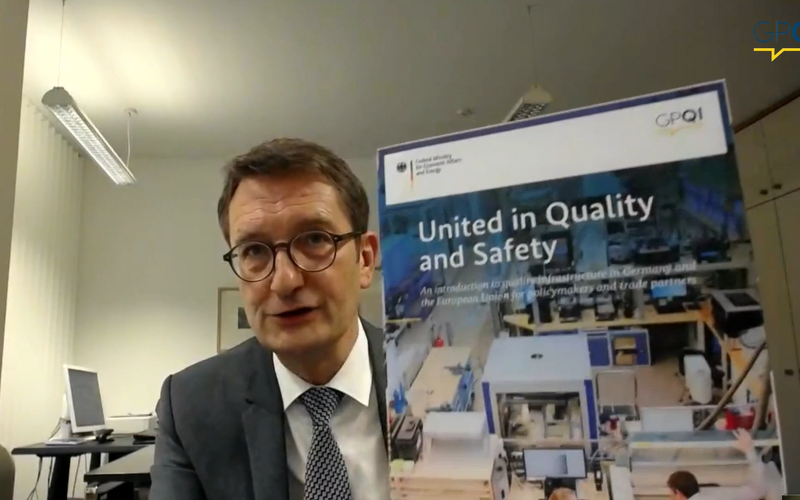 Stefan Schnorr (BMWi) präsentiert die neue Publikation "United in Quality and Safety". Er hält sie in die Kamera.