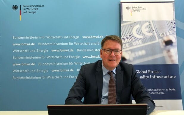Dr. Zielke bei der Vorbereitungssitzung der Deutsch-Chinesischen Kommission zur Zusammenarbeit in der Normung. Er sitzt vor einem Laptop, hinter ihm sind BMWi und GPQI Logos.